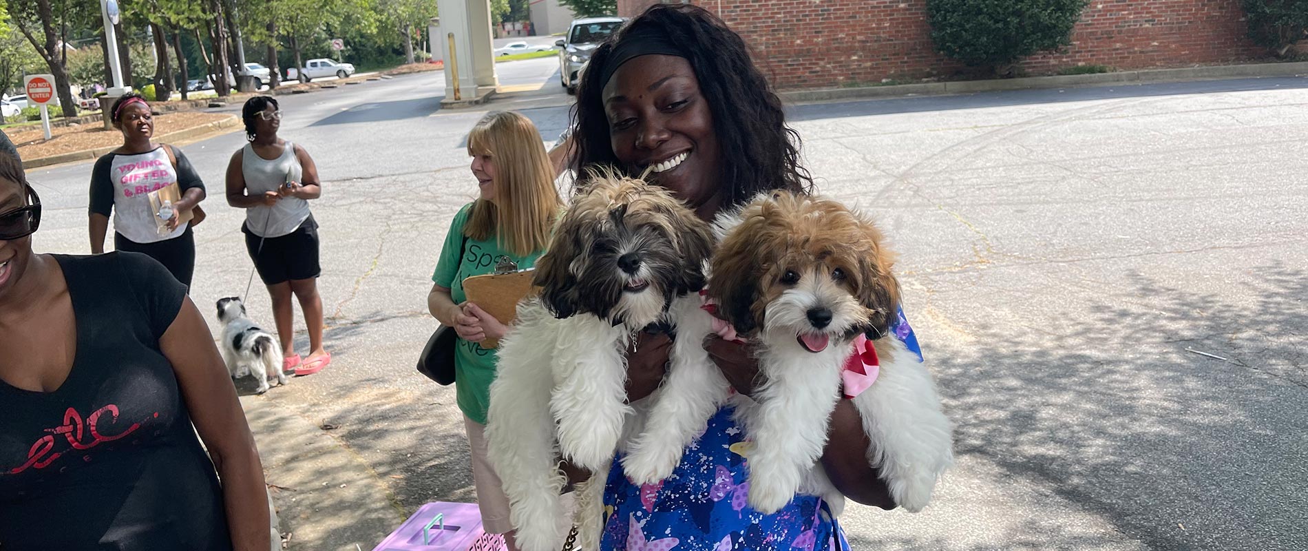 African American lady with 2 dogs at our low-cost Dog & Cat Vaccine Clinics